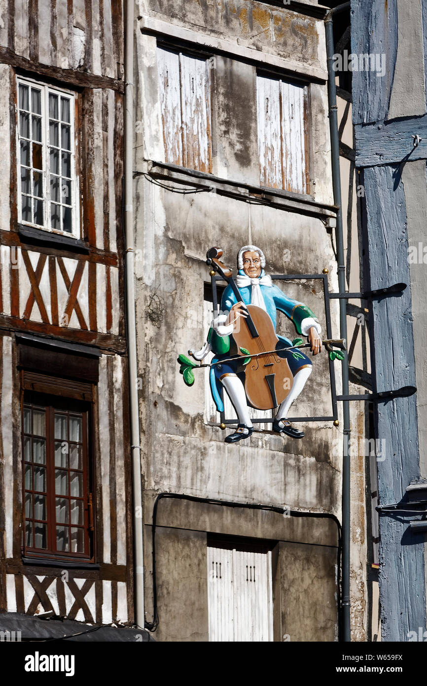 Shop segno, vecchio stile, costume uomo violoncello, in metallo e a struttura mista in legno e muratura edificio, Europa, Normandia; Rouen; Francia; estate; verticale Foto Stock