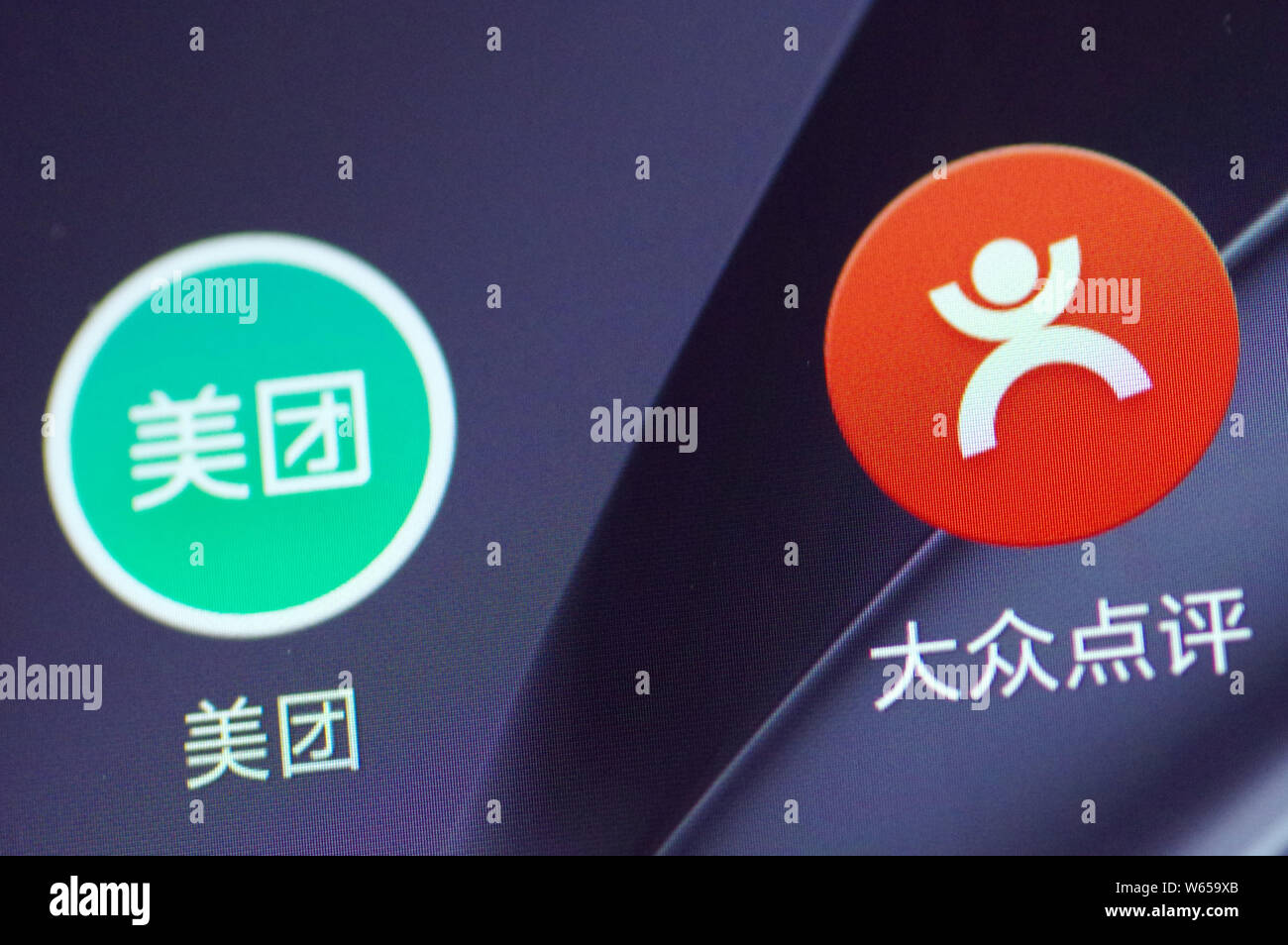 --FILE--un cinese telefono cellulare utente guarda le icone delle app mobile di gruppo online il sito di acquisto meituan.com, sinistra e ristorante servizio di rating diam. Foto Stock