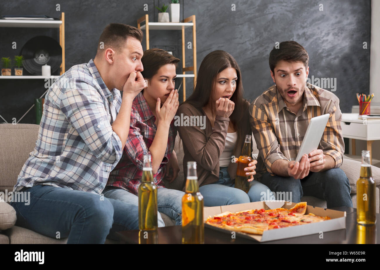 Gli amici a guardare film horror sulla tavoletta digitale in casa Foto Stock Gli amici a guardare film horror sulla tavoletta digitale in casa Foto Stock