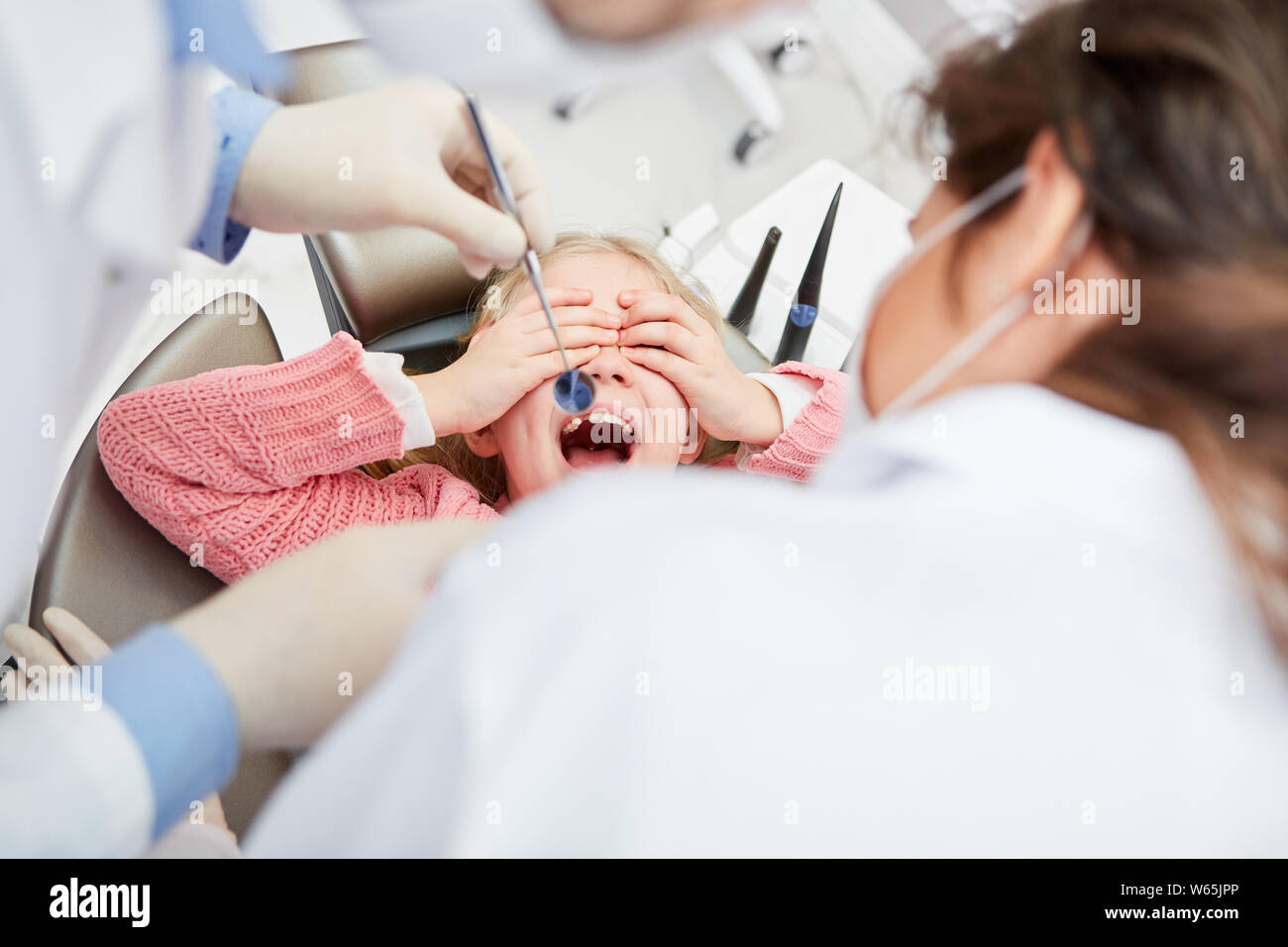 Bambina azienda è fuori dal dentista mentre prendere la precauzione di paura Foto Stock