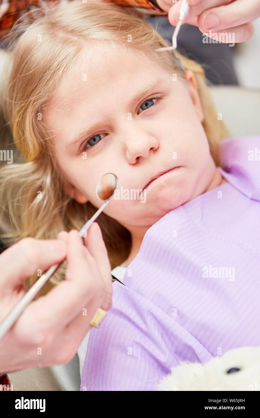 Spaventati ragazza come ansia paziente pizzichi di labbra insieme al dentista durante la manipolazione Foto Stock