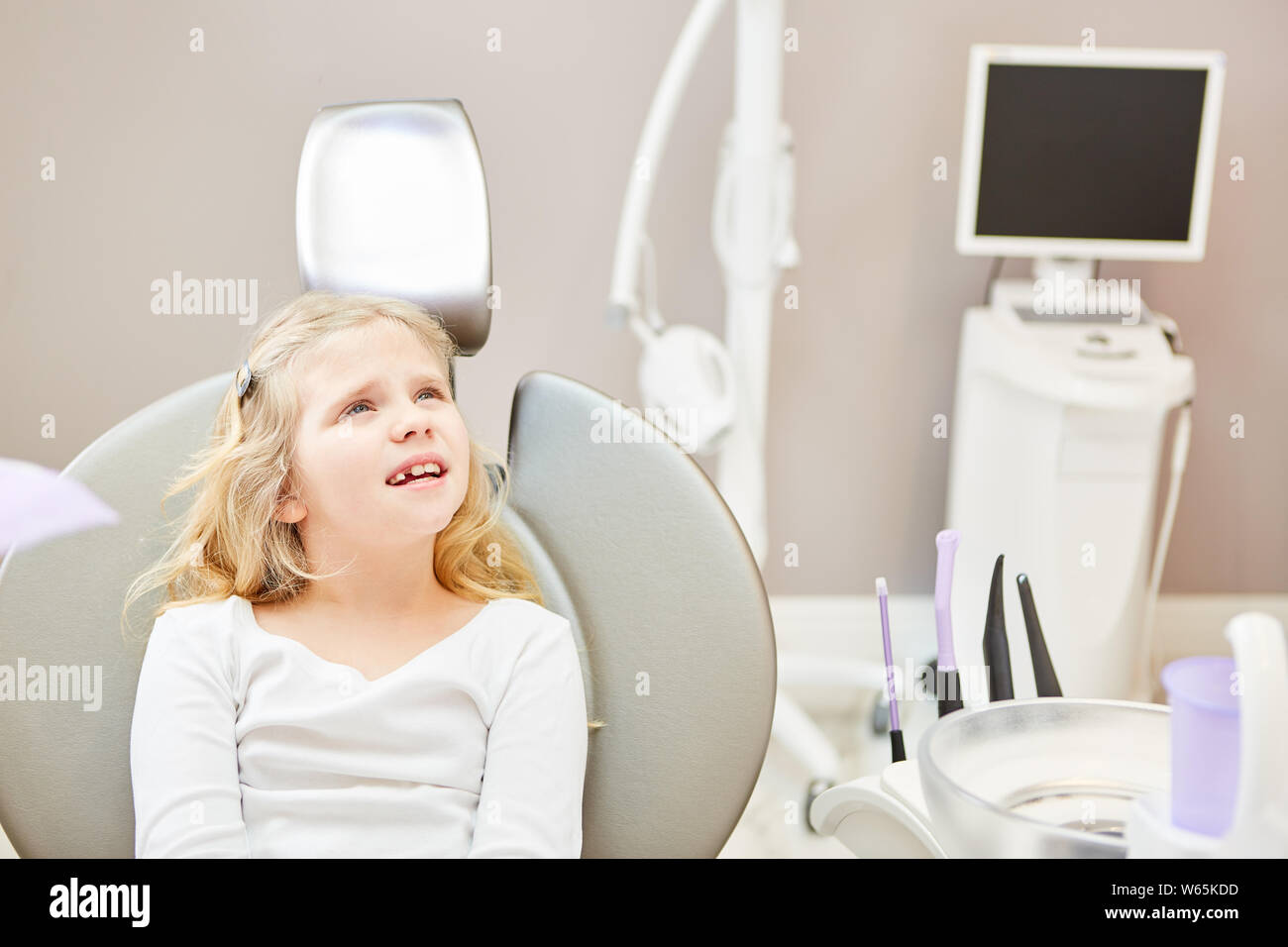 Ansiosi bambina come un paziente presso il dentista è in attesa di esame o di trattamento Foto Stock