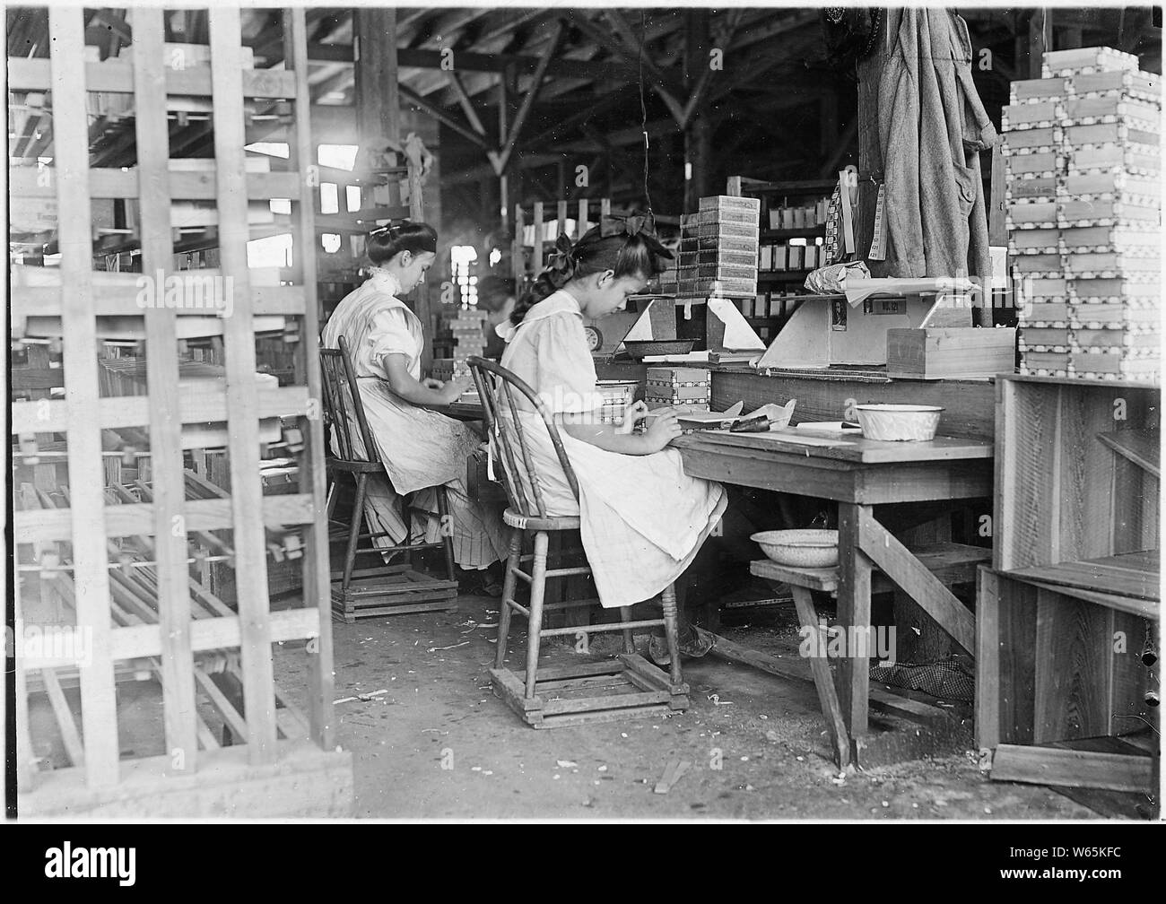 Ragazza che lavora nella casella fabbrica. Ho visto 10 piccoli ragazzi e ragazze che lavorano. Ha una cattiva reputazione per l'occupazione dei giovani, ma il lavoro è il gioco ora. Tampa, in Florida. Foto Stock