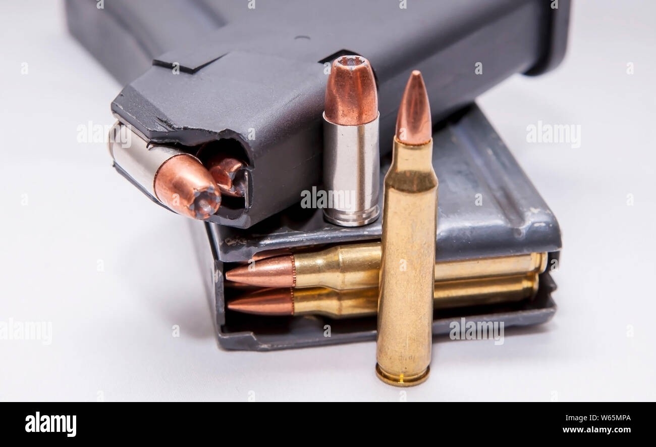 Caricate due riviste, uno per un 9mm pistola e gli altri per un 223 fucile calibro su sfondo bianco Foto Stock