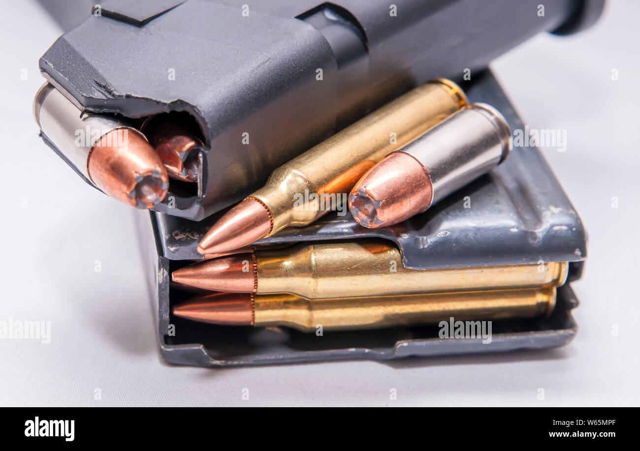 Caricate due riviste, uno per un 9mm pistola e gli altri per un 223 fucile calibro su sfondo bianco Foto Stock