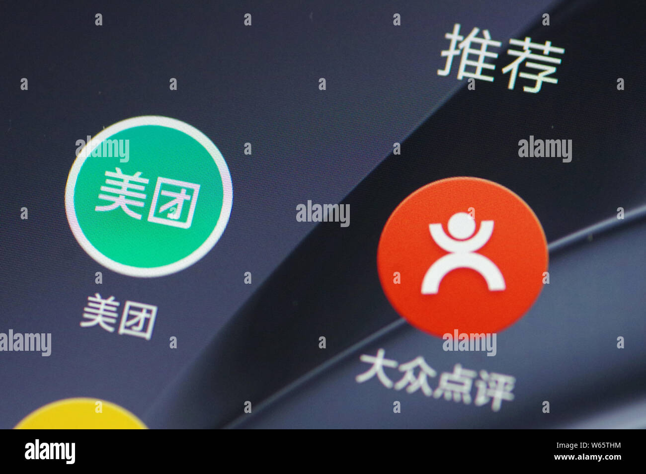 --FILE--un cinese telefono cellulare utente guarda le icone delle app mobile di gruppo online il sito di acquisto meituan.com, sinistra e ristorante servizio di rating diam. Foto Stock