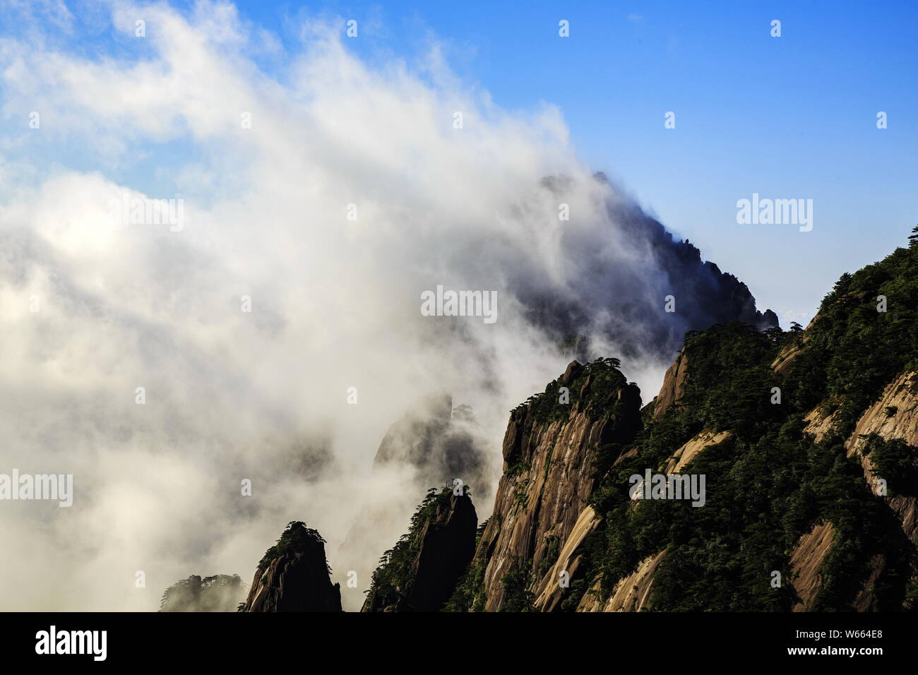 Paesaggio di montagna suggerimenti che si eleva al di sopra delle nuvole incantevole presso la montagna di giallo punto panoramico nella città di Huangshan, est cinese della provincia di Anhui, 24 luglio 2 Foto Stock