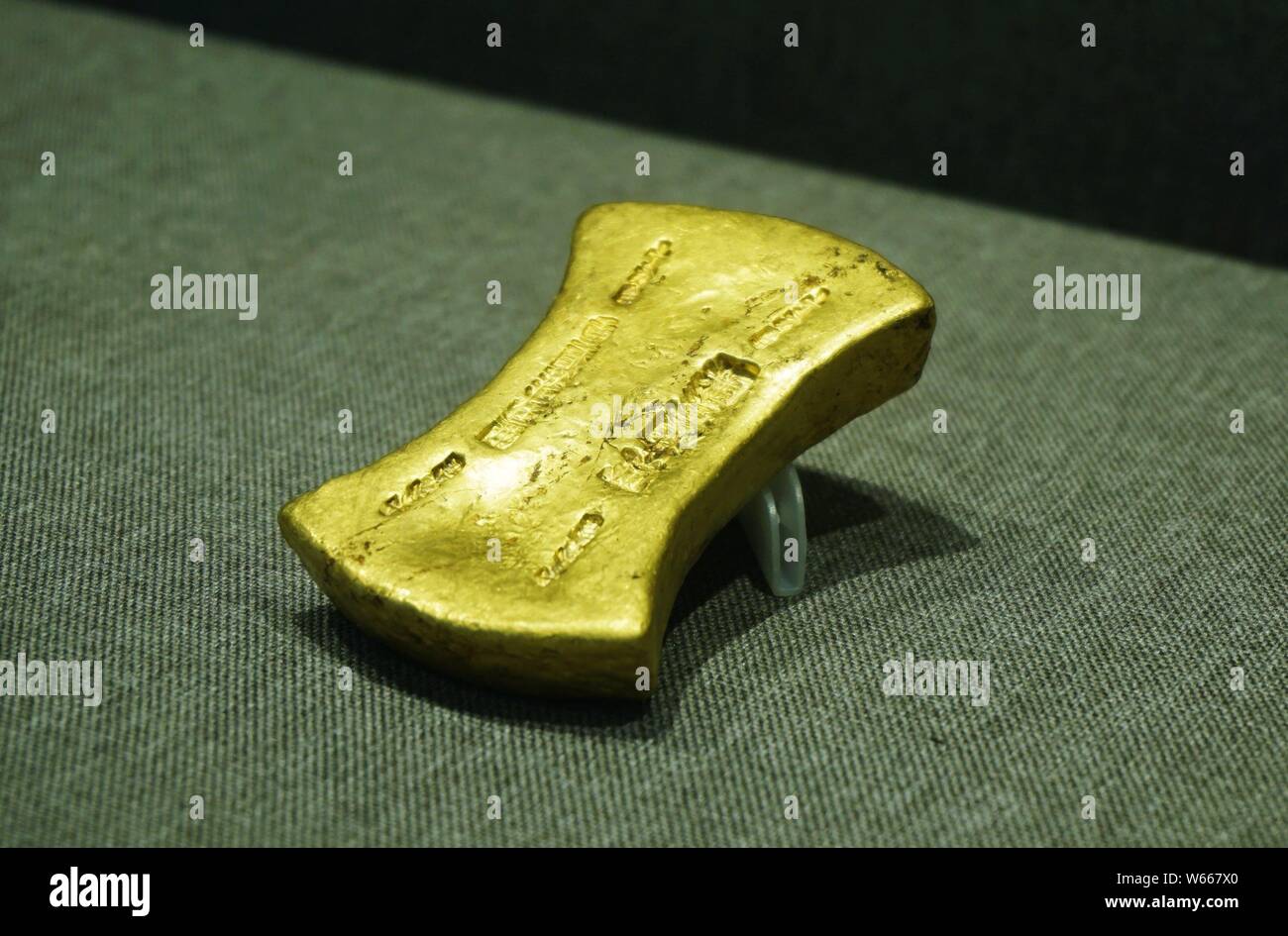 --FILE -- una barra color oro dalla dinastia Southern Song (1127¨C1279) asta a un prezzo elevato di 1.728 milioni di yuan ($258,640) viene visualizzato durante la Xiling Y Foto Stock