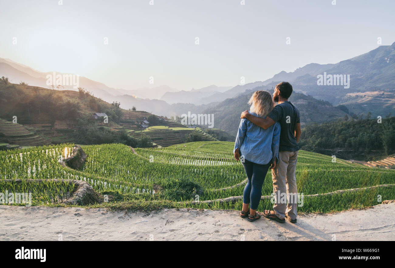 Giovane coppia caucasica guarda alle terrazze di riso di Sapa al tramonto in Lao Cai regione del Vietnam Foto Stock