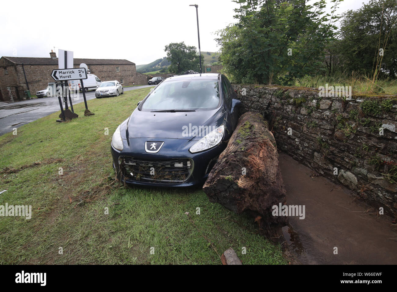 Una vettura che era spingere verso il basso la strada da acqua di inondazione in Grinton, North Yorkshire, dopo le parti della regione avevano fino a 82.2mm di pioggia in 24 ore il martedì. Foto Stock