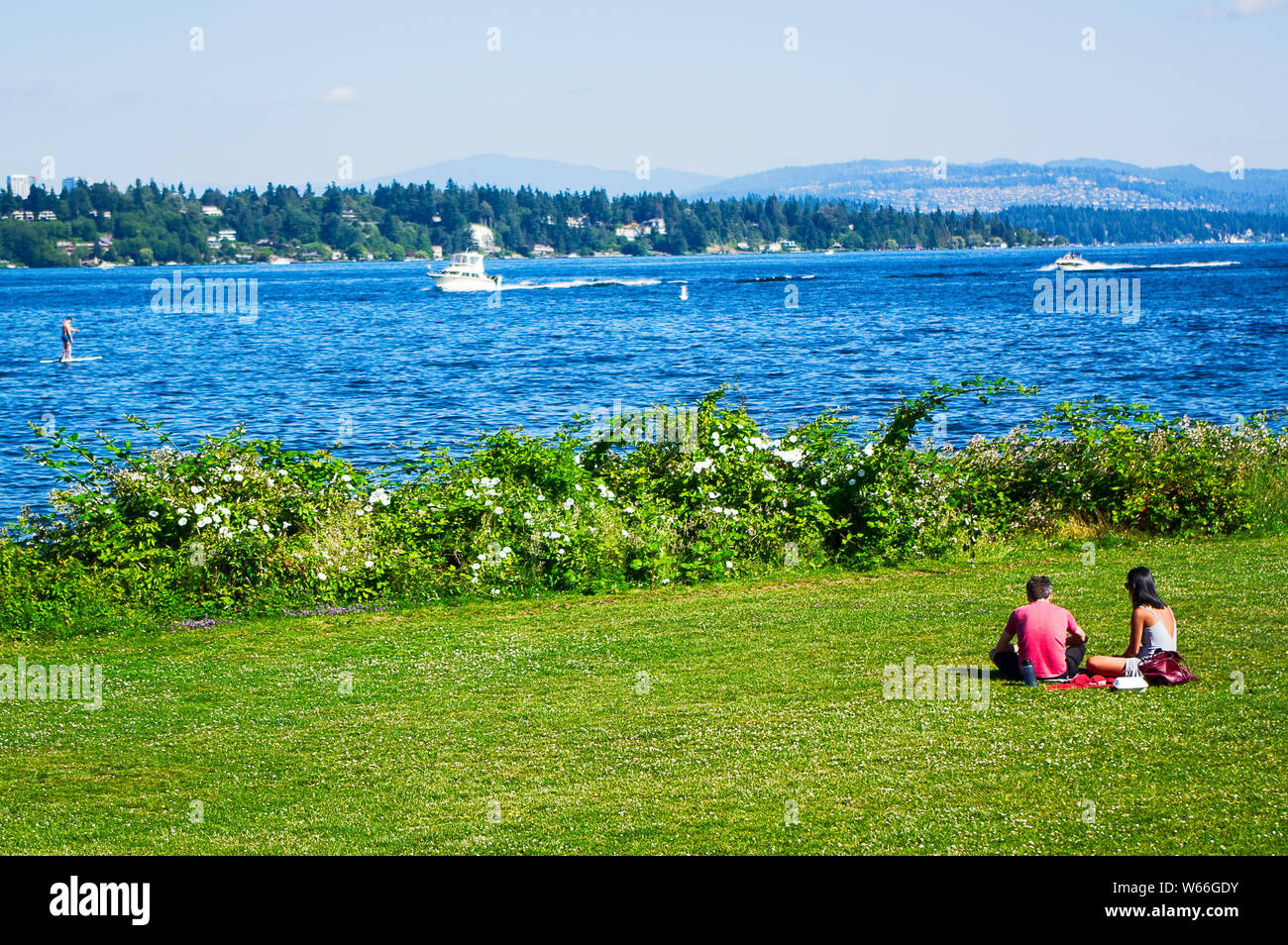 Una coppia avente un picnic nel parco, sul bordo del lago Washington, Foto Stock