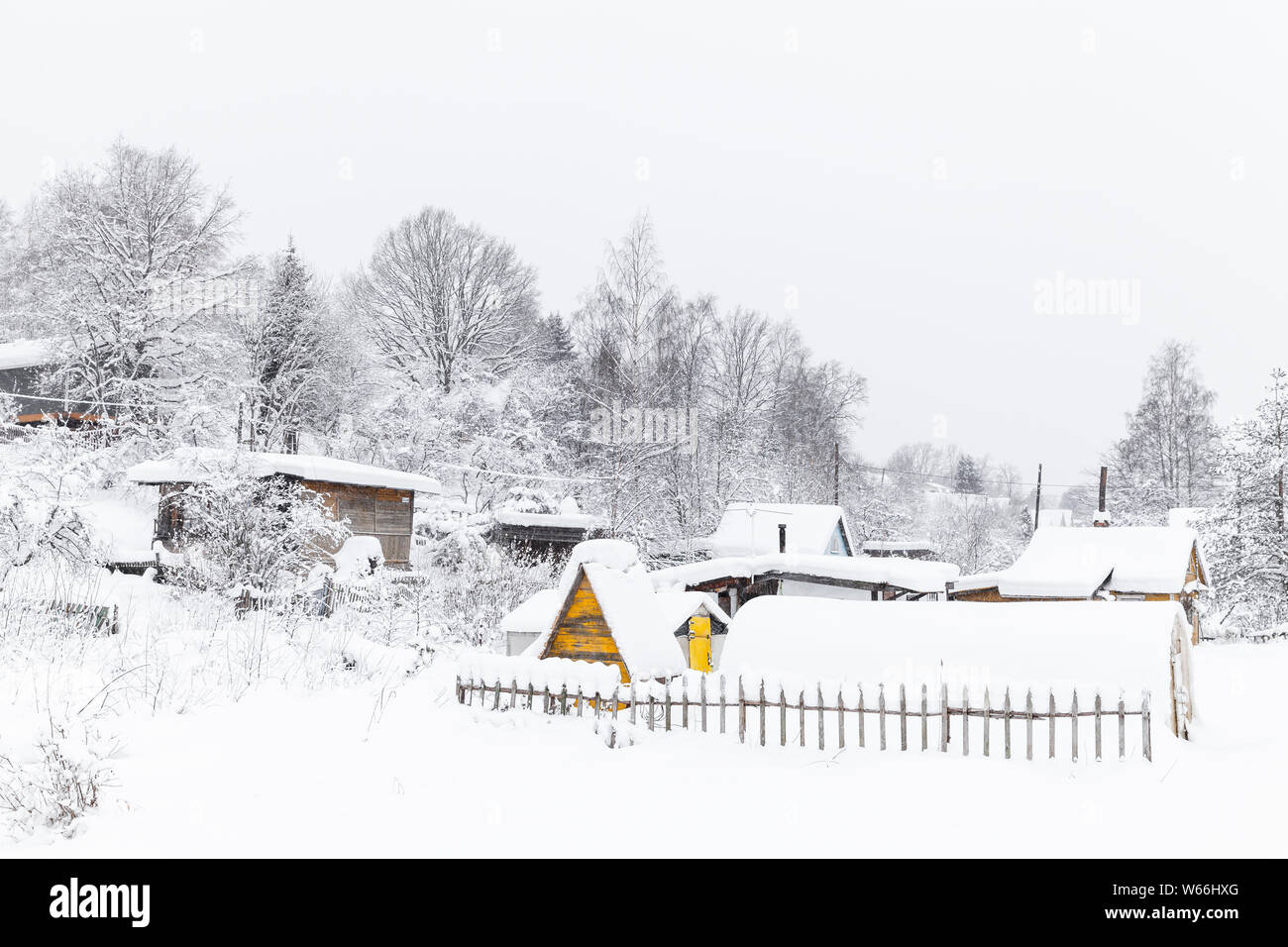 Inverno russo paesaggio rurale con alberi innevati e case di villaggio di giorno Foto Stock