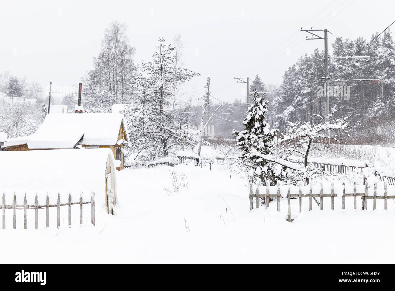 In inverno il paesaggio rurale con alberi innevati e case di villaggio di giorno Foto Stock