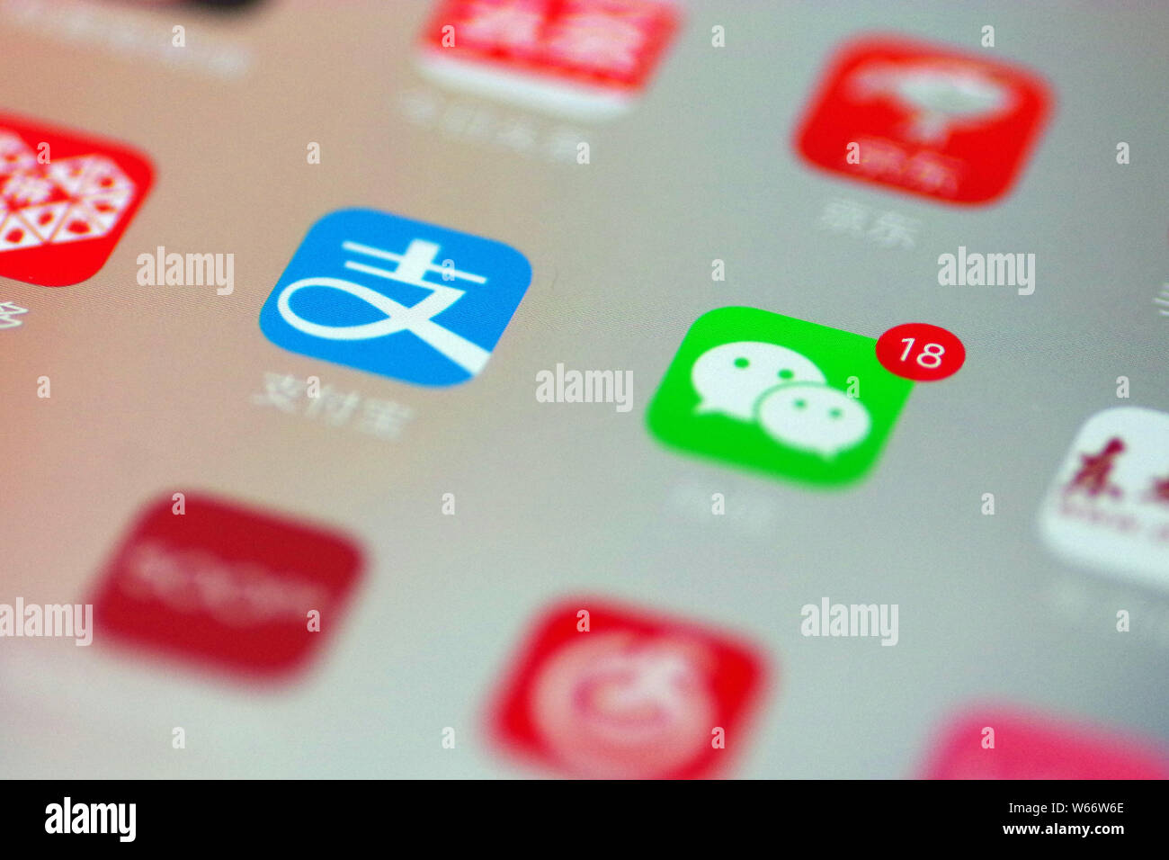 --FILE--un cinese telefono cellulare utente guarda le icone delle app di Alipay, sinistra, il servizio di pagamento online di cinesi e-commerce giant Alibaba è un Foto Stock