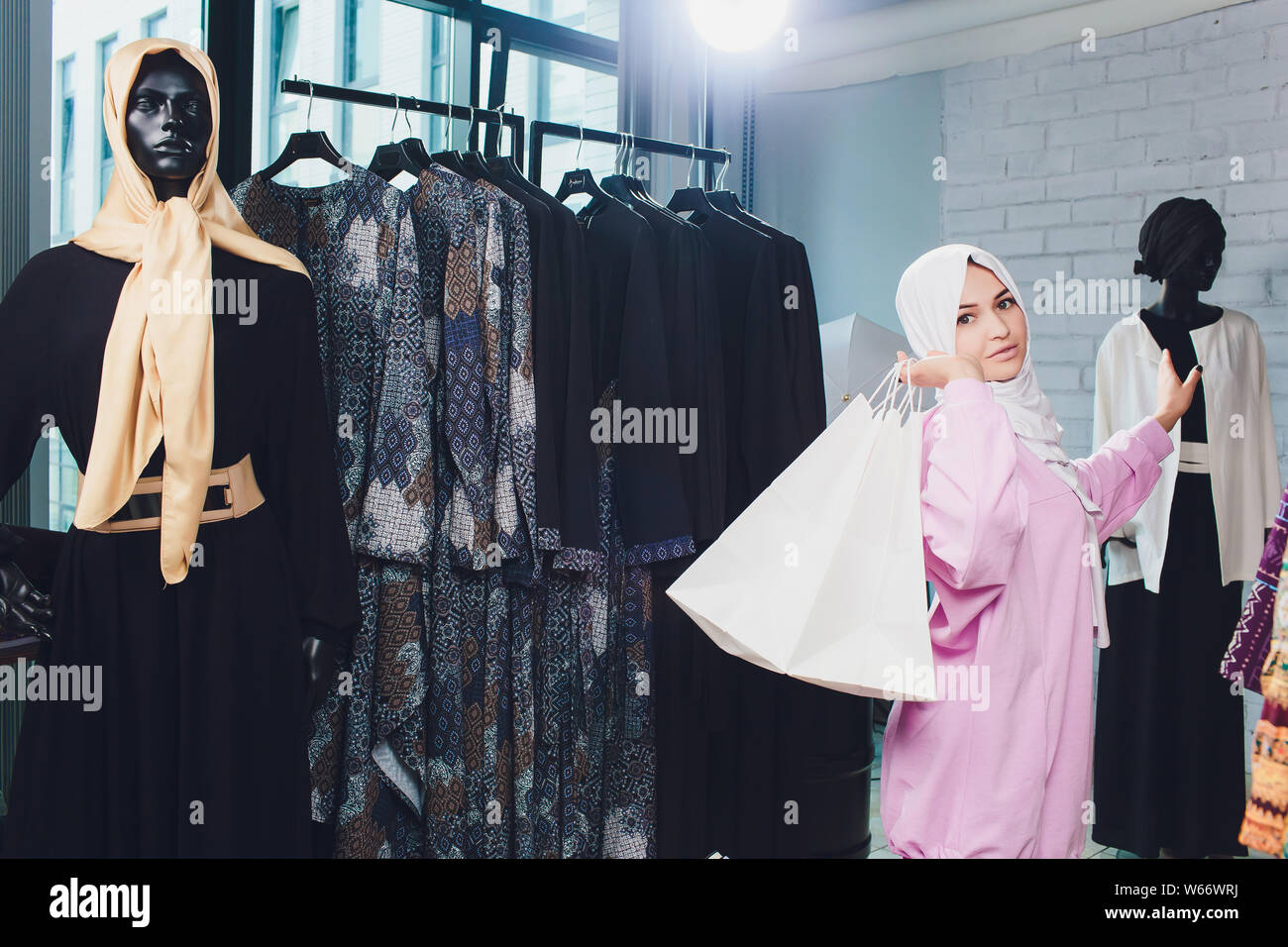La donna araba in tradizionali abiti musulmani compra un nuovo vestito in un negozio orientale. Foto Stock
