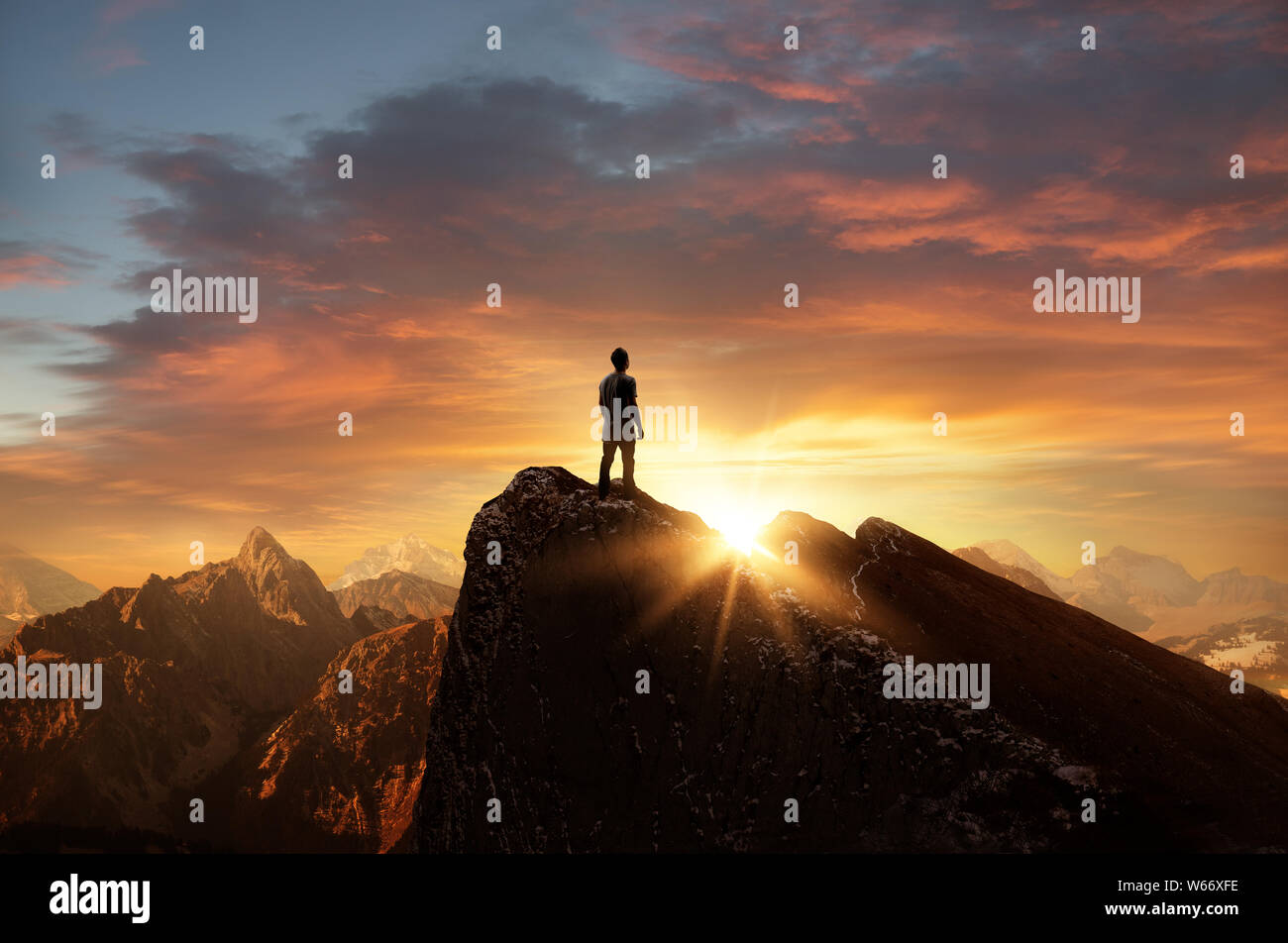 Un uomo in piedi sulla cima di una montagna come il sole tramonta. Obiettivi e risultati foto concetto composito. Foto Stock