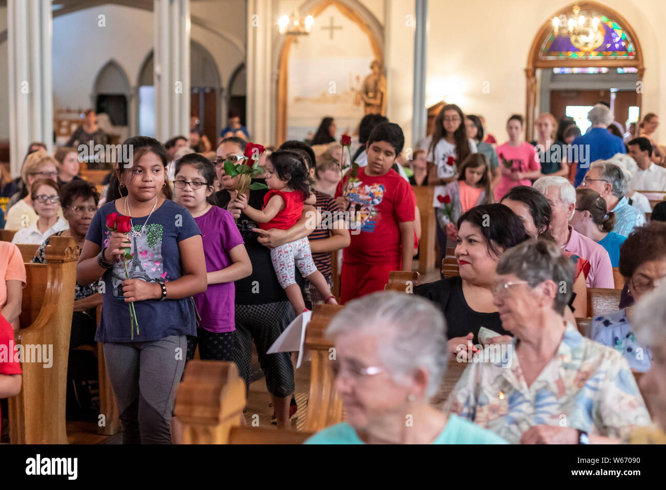 Detroit, Michigan - una messa cattolica per famiglie di immigrati che sono separati o in stato di detenzione. Una sfilata di bambini durante l offertorio posto flo Foto Stock