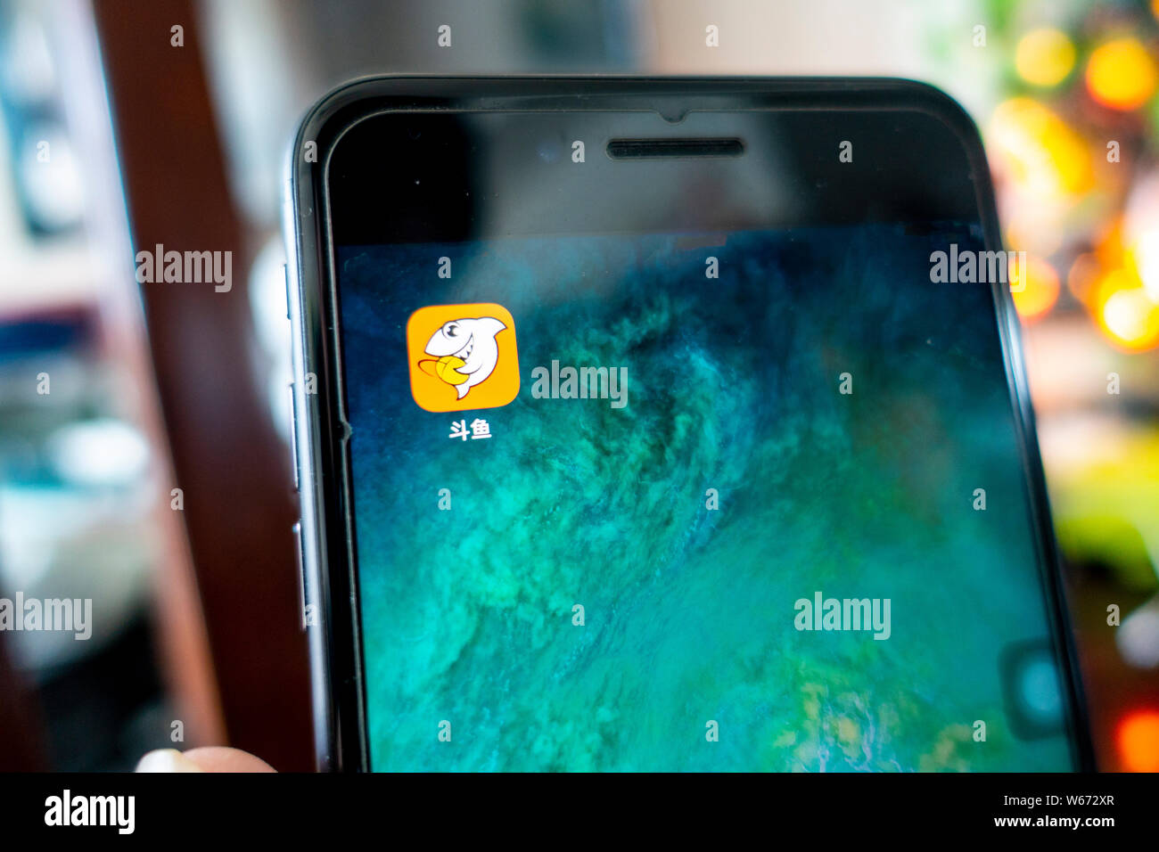 --FILE--un cinese telefono cellulare utente guarda l'icona del gioco cinese video streaming platform Douyu, o 'lotta contro la pesca', sul suo smartphone in Shangha Foto Stock