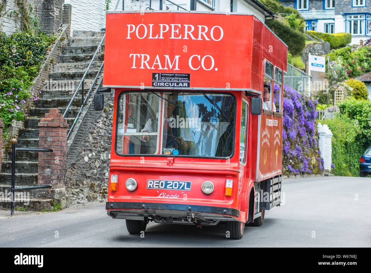 Caratteristico bus rosso che stava trasportando i turisti nel pittoresco villaggio di Polperro in Cornovaglia, England, Regno Unito Foto Stock