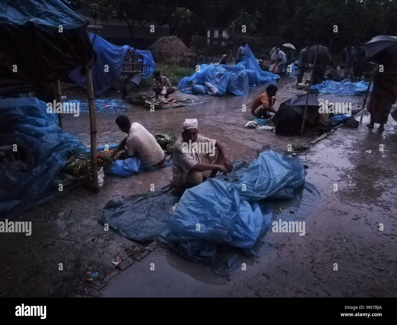 Luglio 31, 2019, Naogaon, Bangladesh: una vista di un settimanale mercato rurale come fornitori utilizzano fogli di plastica per salvare dalla pioggia nella periferia di Dhamoirhat, Naogaon. Credito: MD Mehedi Hasan/ZUMA filo/Alamy Live News Foto Stock