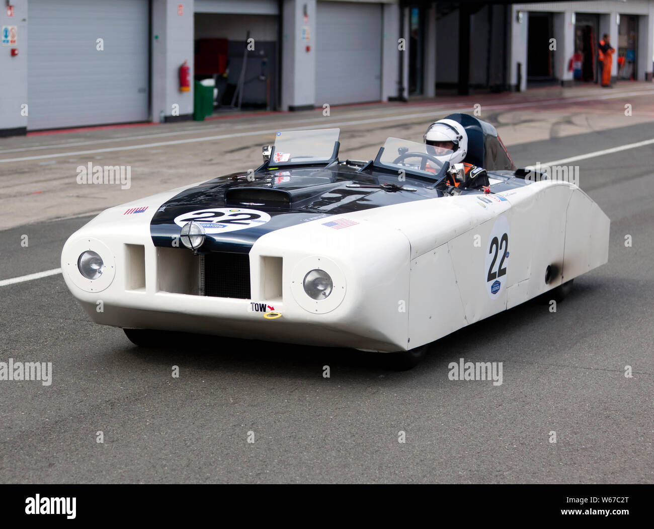 Dereck Drinkwater guida del Cunningham-Walters Cadillac Le Monstre la guida verso il basso il National Pit Lane, durante il 2019 Silverstone Classic Foto Stock