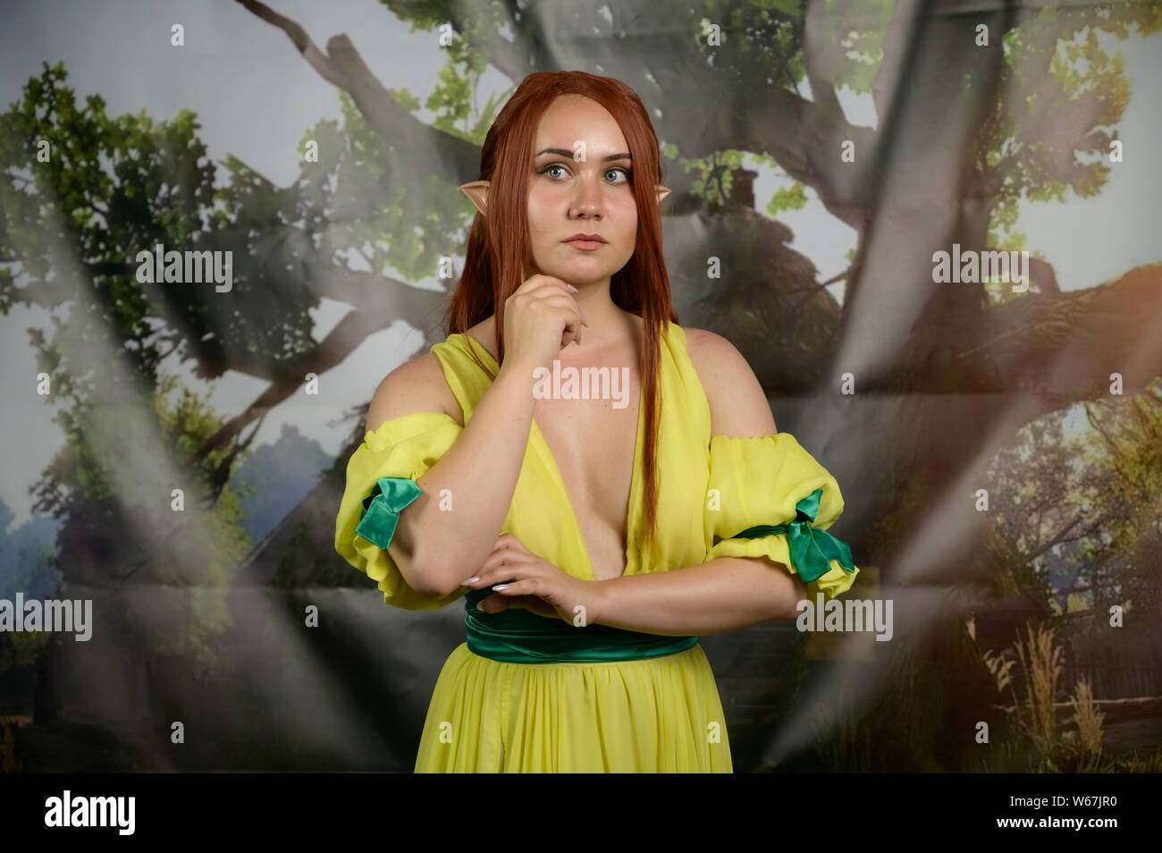 VLADIVOSTOK, RUSSIA - Luglio 20, 2019: Festival del gioco e una serie di libri serie Witcher. Cosplayer come elf in posa contro lo sfondo colorato. Foto Stock