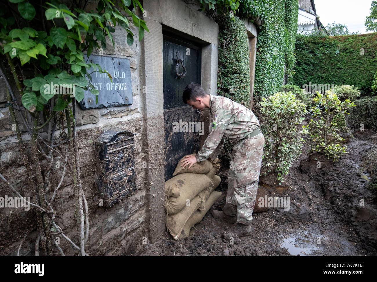 Un soldato da 2 Yorks Stack i sacchi di sabbia in Grinton, North Yorkshire dopo che parti della regione avevano fino a 82.2mm di pioggia in 24 ore il martedì. Foto Stock