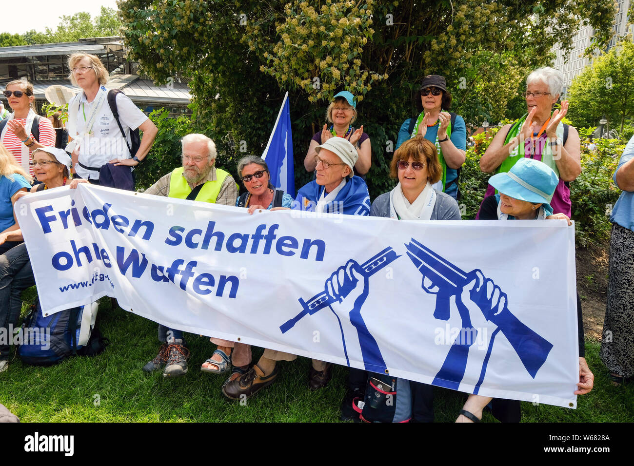 Attivisti per la pace con la bandiera con lo slogan "pace senza armi' durante una dimostrazione di pace presso la chiesa protestante di Germania il Congresso 2019 a Dortmund, Germania Foto Stock