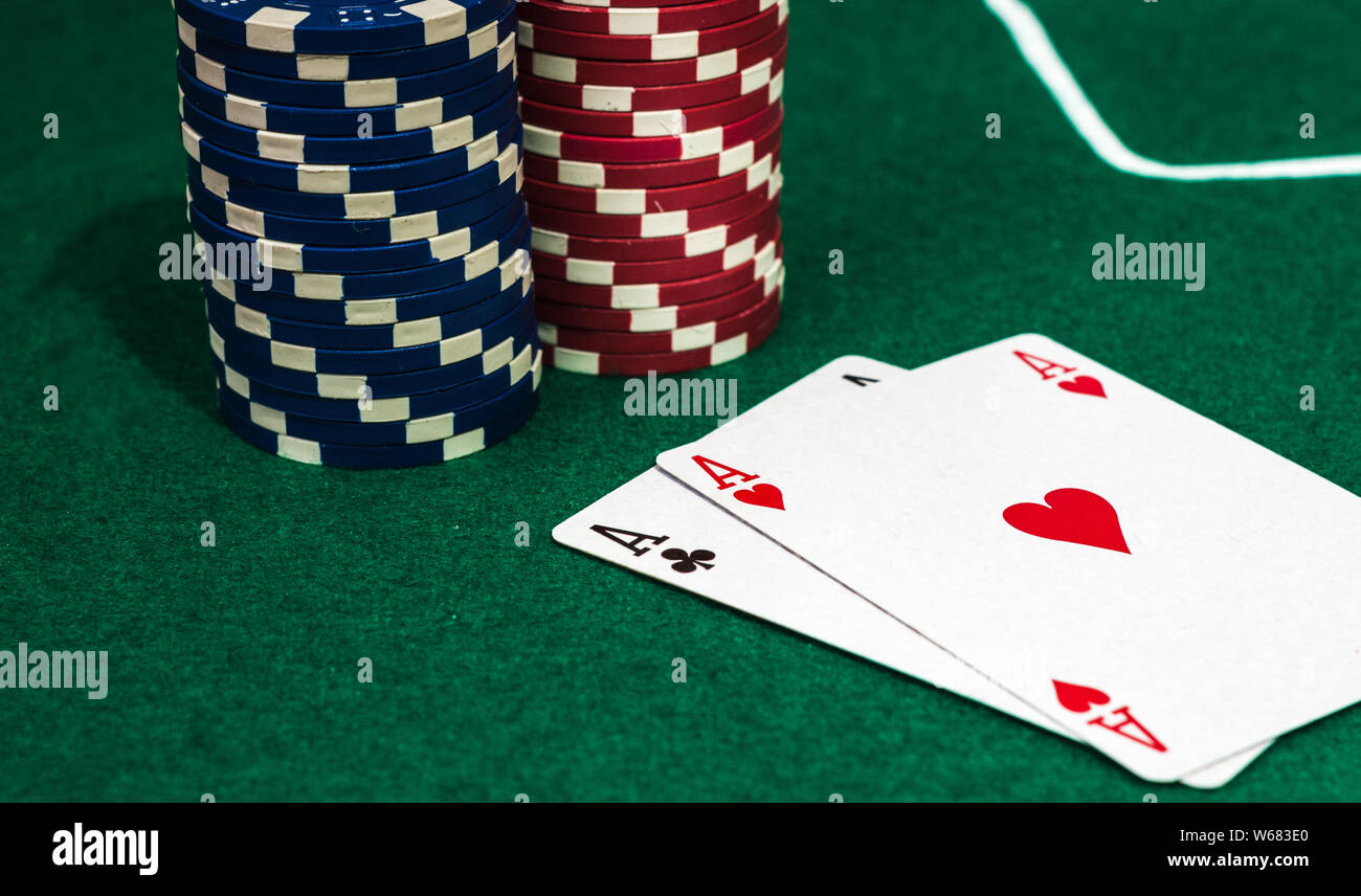 Coppia di Assi e poker chips sul tappeto verde 2 Foto Stock