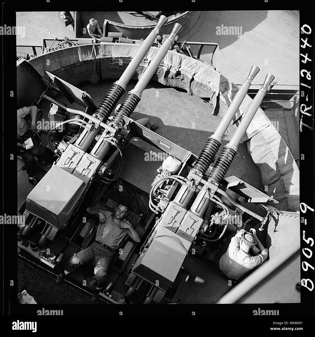 Sailor addormentato tra 40mm cannoni a bordo della USS New Jersey (BB-62). Foto Stock