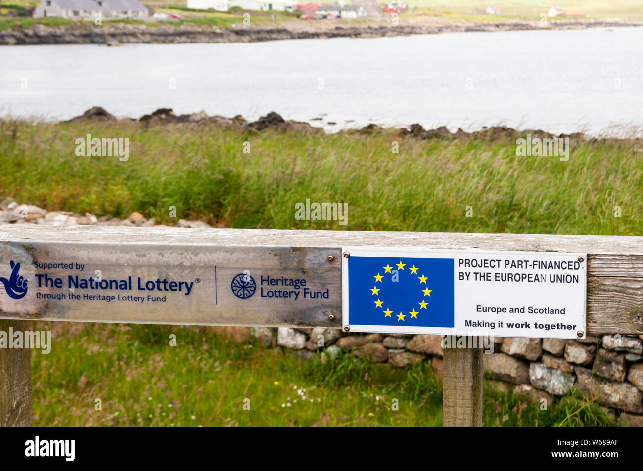 Placca alla replica Viking house & nave su Unst Shetland nel progetto di legge Part-Financed dall'Unione europea, Europe & Scozia facendolo funzionare insieme Foto Stock