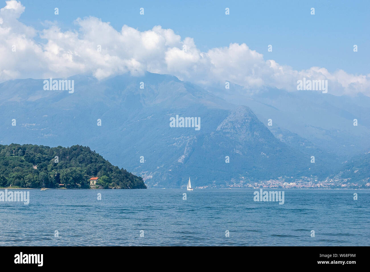 Vista del lago di montagna e il pomontory su una soleggiata giornata estiva. Distretto del Lago di Como, Colico, Italia, Europa. Foto Stock