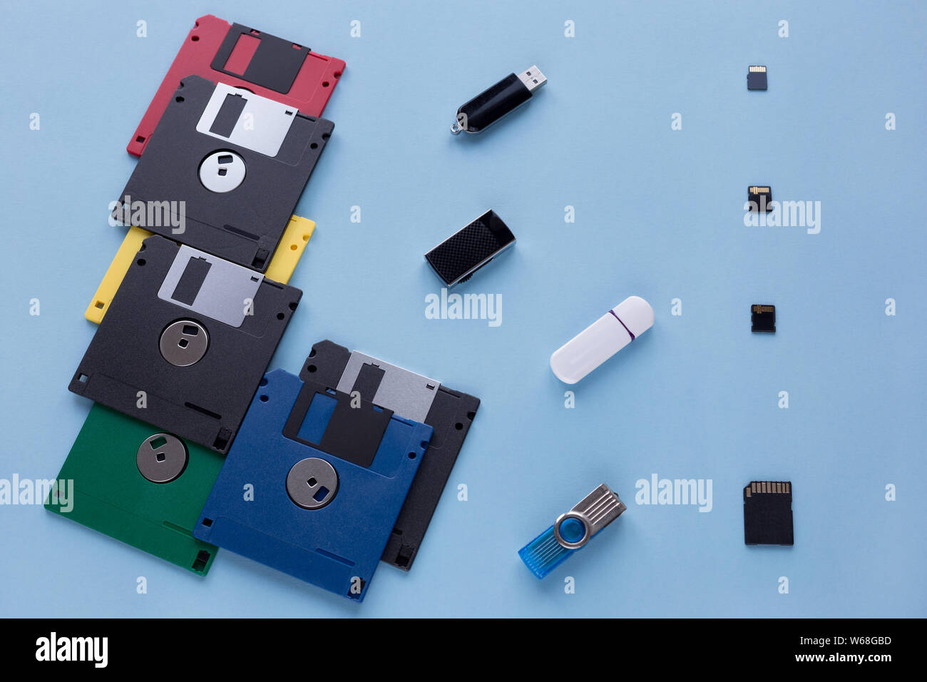 L'evoluzione dei dati digitali del dispositivo di storage. I dischi floppy, unità flash e piccole schede di memoria. Isolato su uno sfondo blu. Foto Stock