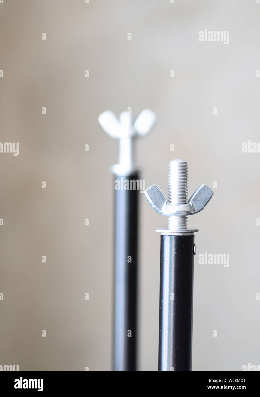 Il carving su piedistallo durale con un dado a farfalla. Messa a fuoco selettiva. Due rack per accessori fotografici. Foto Stock