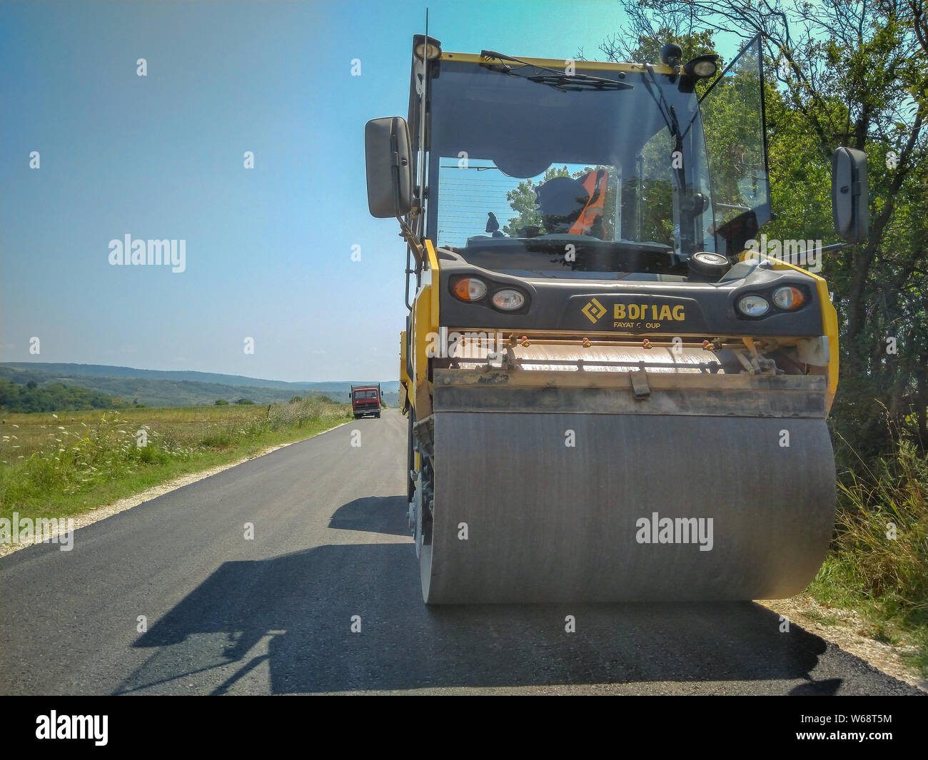 Macchine di asfaltatura sul sito in costruzione pronta per il funzionamento su strada Foto Stock