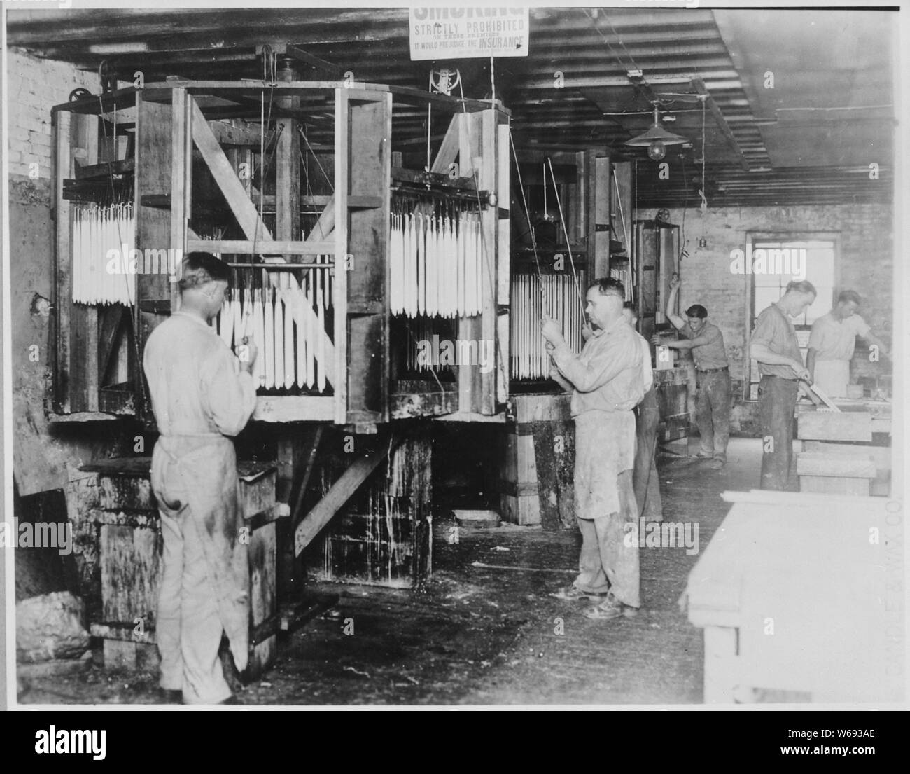 Operai a mano candele di immersione al Saint Louis candela e Wax Company, 1927 Foto Stock