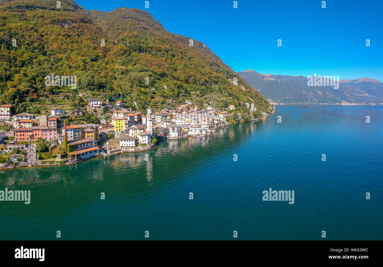 Vista aerea orizzontale sul bellissimo Lago di Como in Lombardia, Italia. Scenic piccolo borgo con case tradizionali e chiare acque blu. Turistica estiva "vacatio Foto Stock