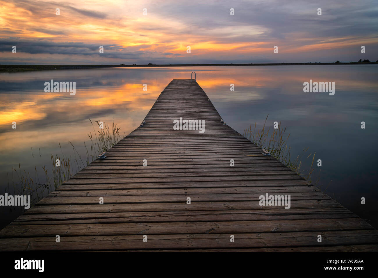 Le nuvole riflettono nelle acque di Lon Hagler serbatoio situato nella contea di Larimer Colorado come il molo dei pescatori attende i pescatori Foto Stock