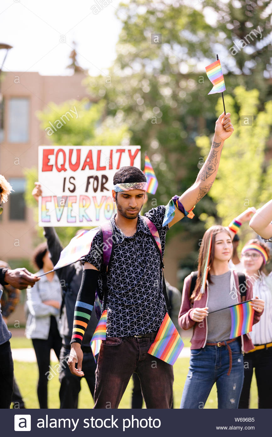 Studente azienda bandiera arcobaleno al Gay Pride marzo Foto Stock