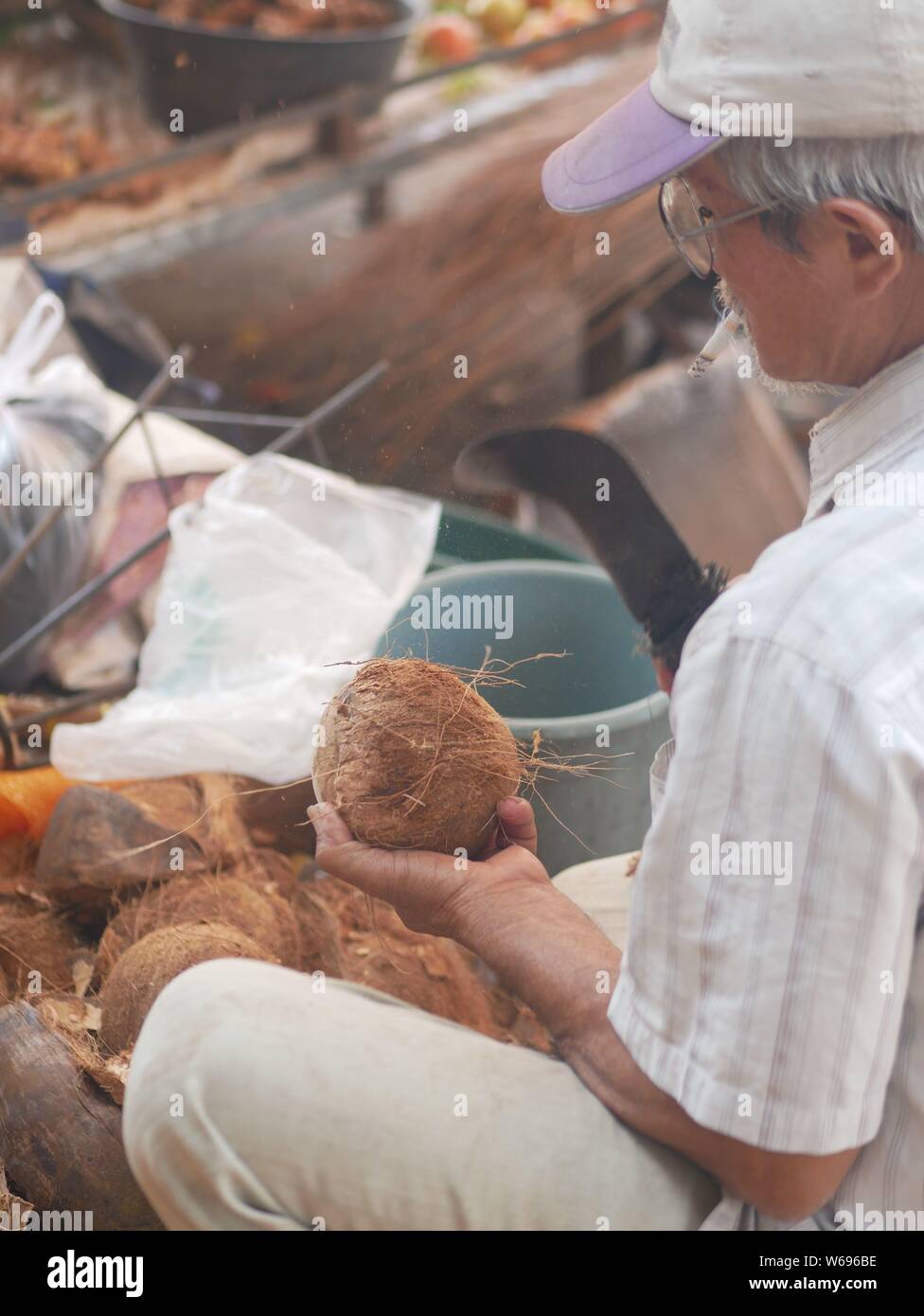 12 dicembre 2019 - Kediri, Indonesia: Commerciante con cocco nei mercati tradizionali a Pare, Kediri, Indonesia Foto Stock