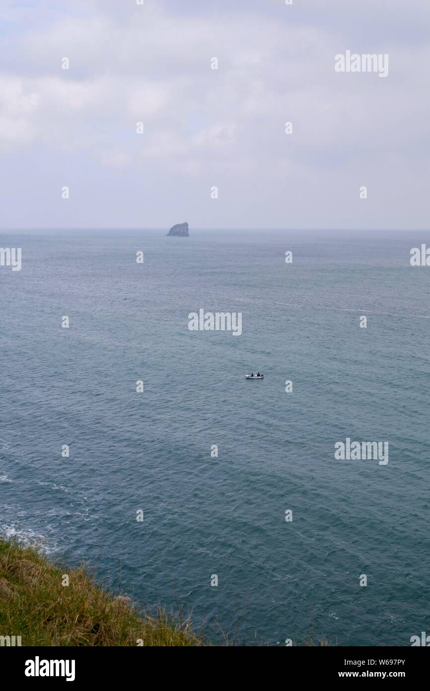 Piccola imbarcazione aperta con i pescatori pesca in mare lungo la North Cornish Coast presso Sant Agnese testa con Bawden rocce in lontananza su una giornata di primavera. Regno Unito. Foto Stock