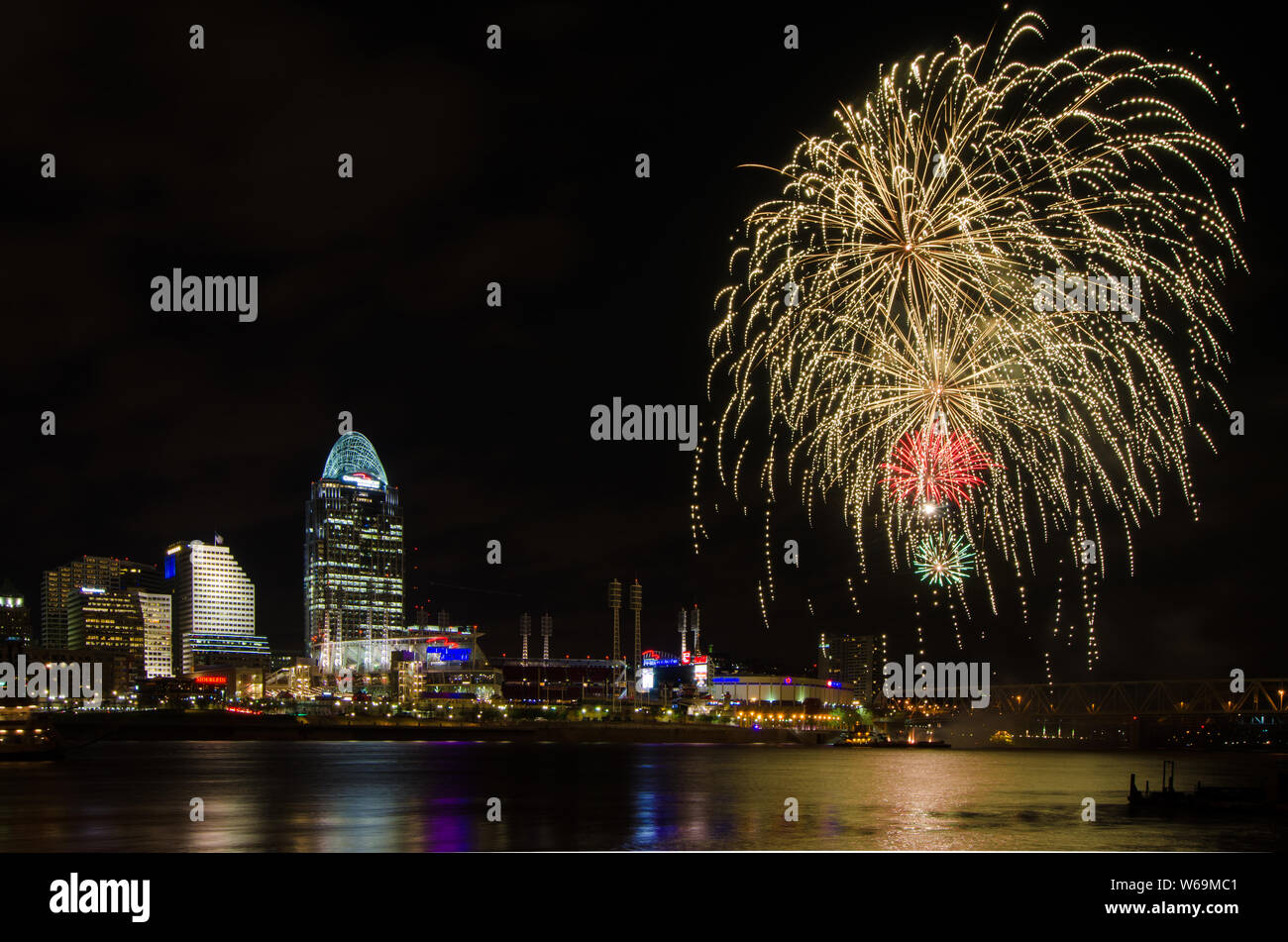Il lancio di fuochi d'artificio da una chiatta nel fiume Ohio a Cincinnati, Ohio, Stati Uniti d'America, contro Cincinnati cityscape, compresi Great American Ball Park. Foto Stock