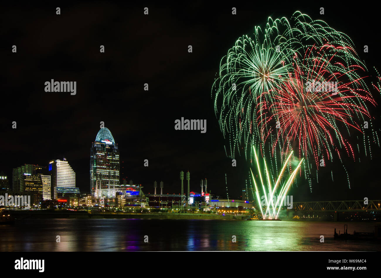 Il lancio di fuochi d'artificio da una chiatta nel fiume Ohio a Cincinnati, Ohio, Stati Uniti d'America, contro Cincinnati cityscape, compresi Great American Ball Park. Foto Stock