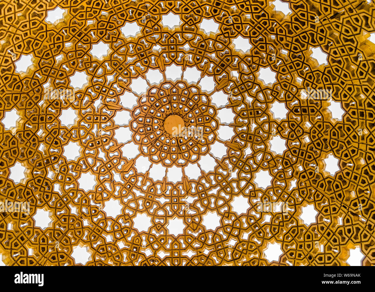 Guardando il cielo attraverso i motivi complessi di golden gazebo cupola in Muscat Oman. Foto Stock