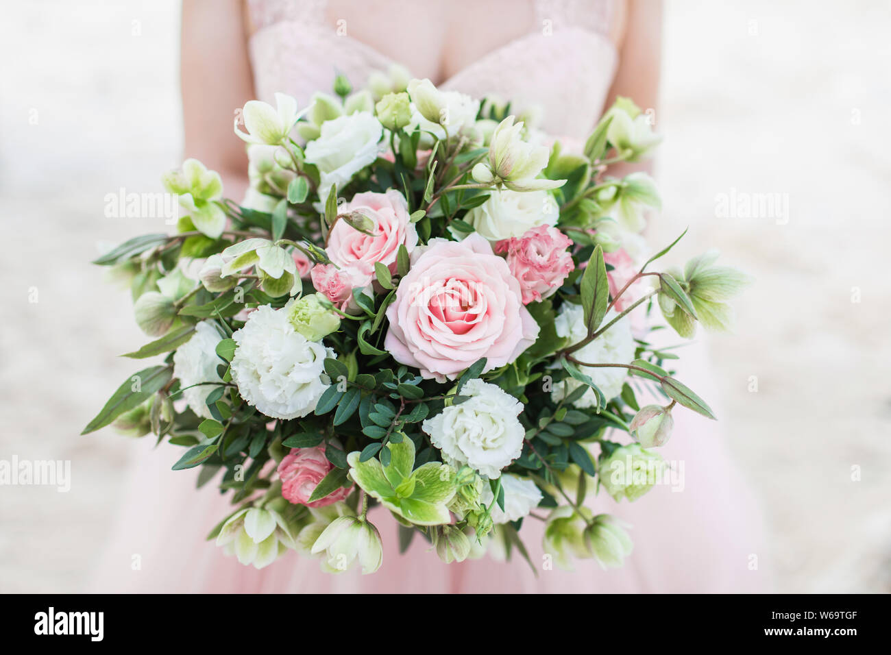 Bellissimo mazzo di nozze nella donna le mani, rosa rosa, tulipani, garofano, verdi. Colore pastello chiaro. Foto Stock