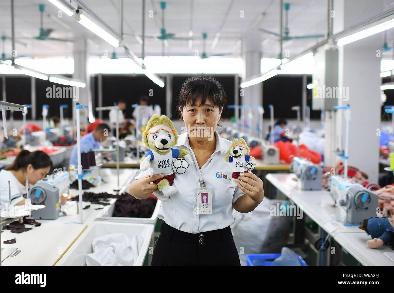 In questa foto non datata, cinese un lavoratore di sesso femminile che mostra i giocattoli della 2018 FIFA World Cup Russia Zabivaka mascotte il lupo in una fabbrica in Cina. Sebbene Chi Foto Stock