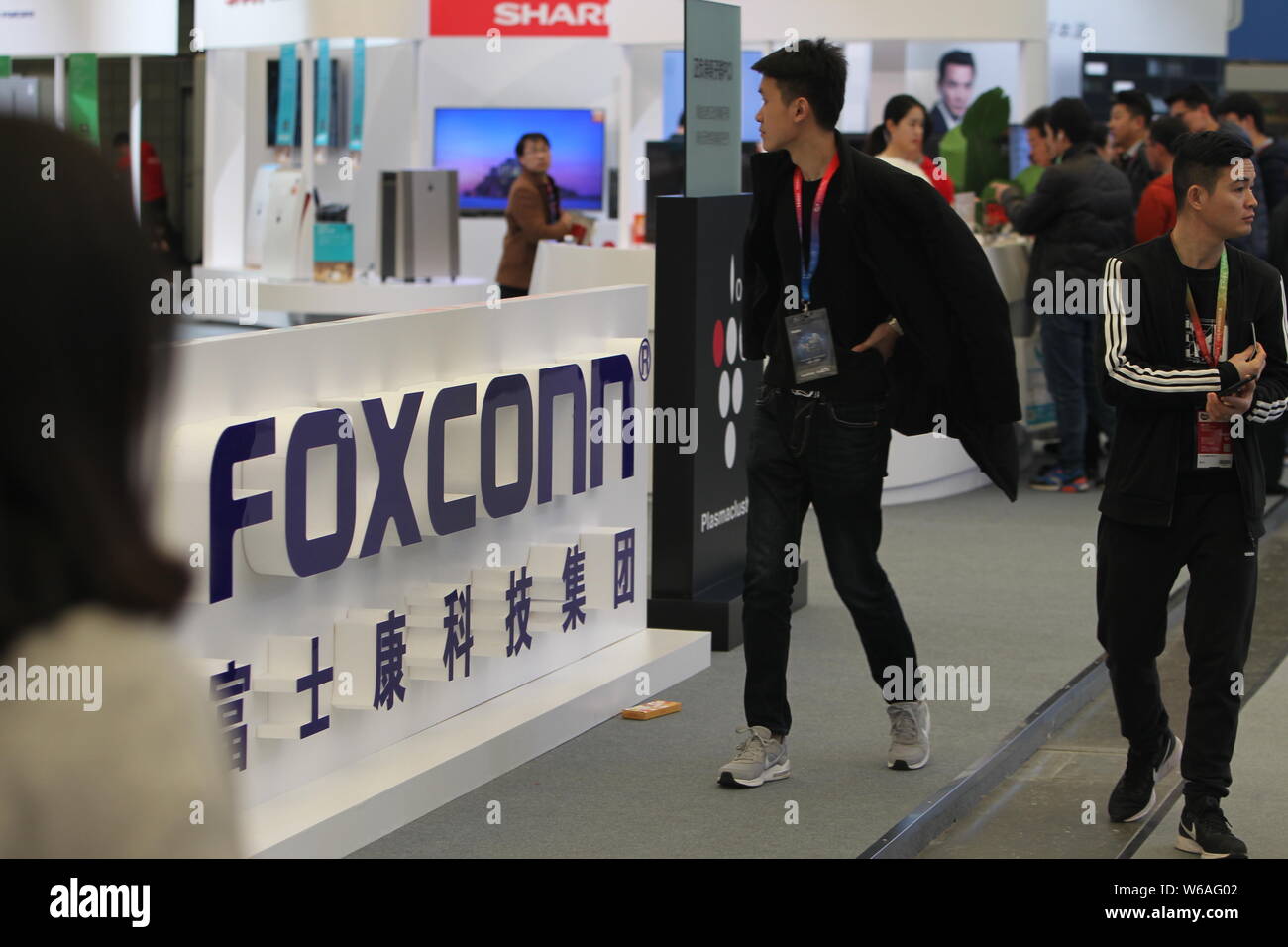 --FILE--i visitatori a piedi passato lo stand della Foxconn durante una mostra a Shanghai in Cina, 11 marzo 2018. Produttore di elettronica ha rotto Foxconn polv Foto Stock
