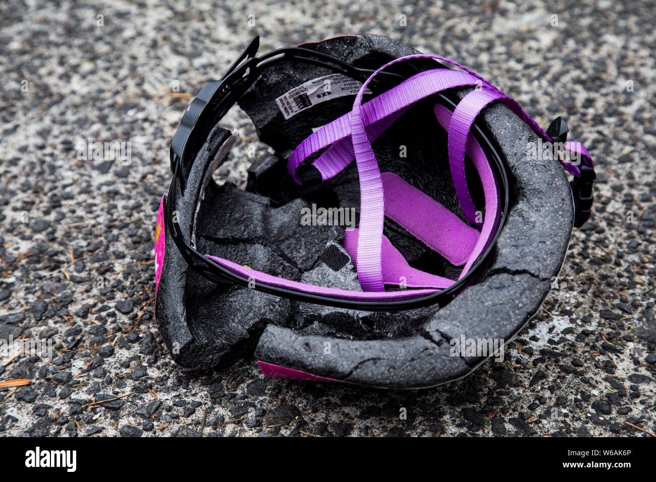 Per i bambini la principessa rosa casco con cinghie di viola. Schiacciato dalle ruote di una station wagon. Interno incrinato e shell. Sarebbe un grave danno alla testa. Foto Stock