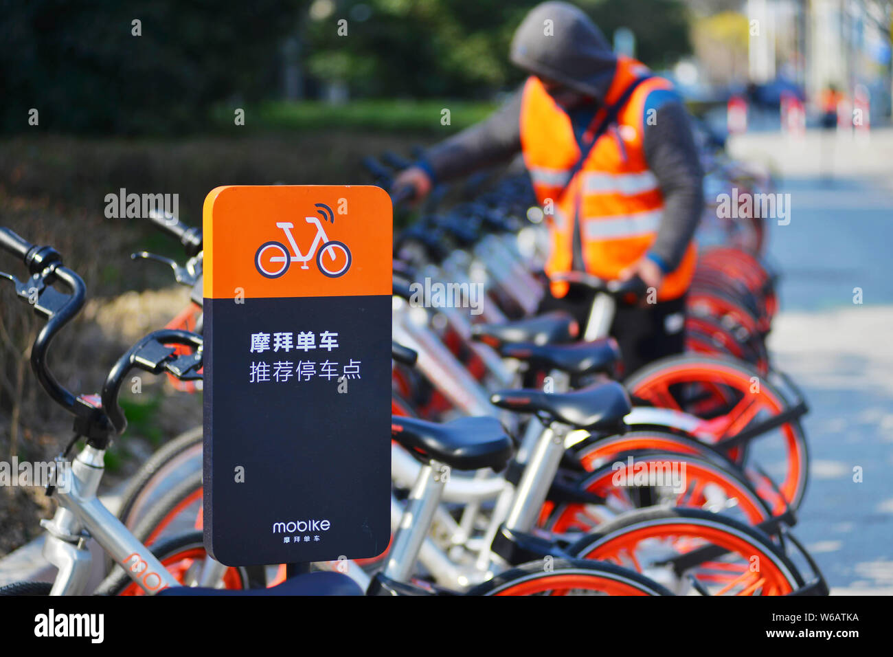 --FILE--un lavoratore cinese visualizza le biciclette cinesi di bike sharing service Mobike presso un parcheggio Mobike sito su una strada in Cina a Shanghai, 2 marzo 2017. Foto Stock