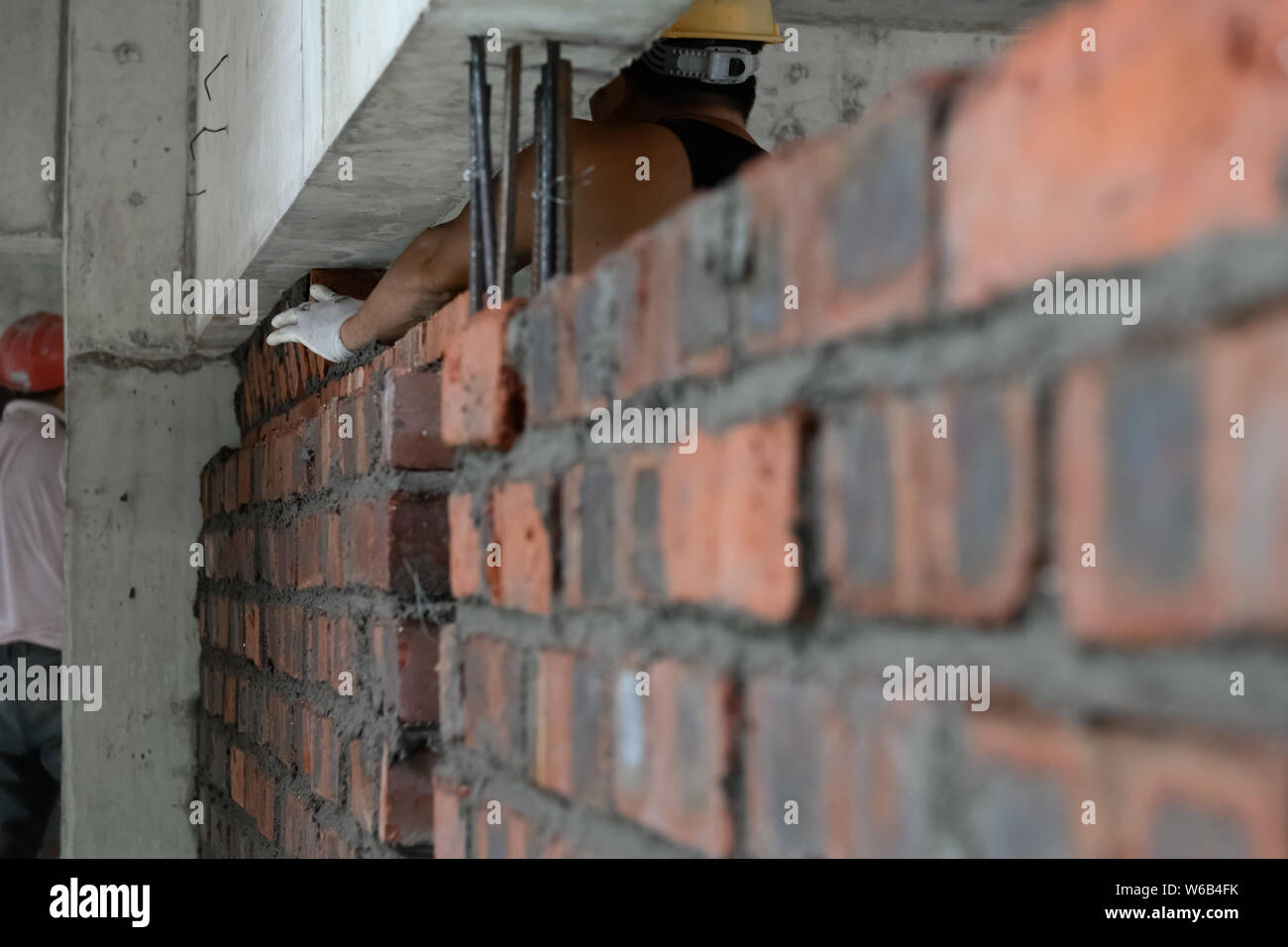 Stuccatore che compongono un muro di mattoni con cemento Foto Stock
